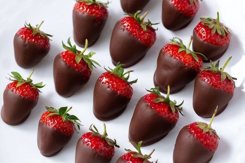 Chocolate-covered strawberries arranged on a white surface. 2