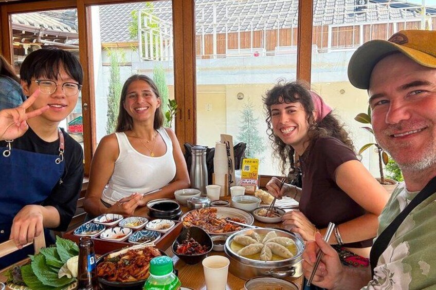 A group of people dining at a restaurant with various dishes and drinks on the table. 3
