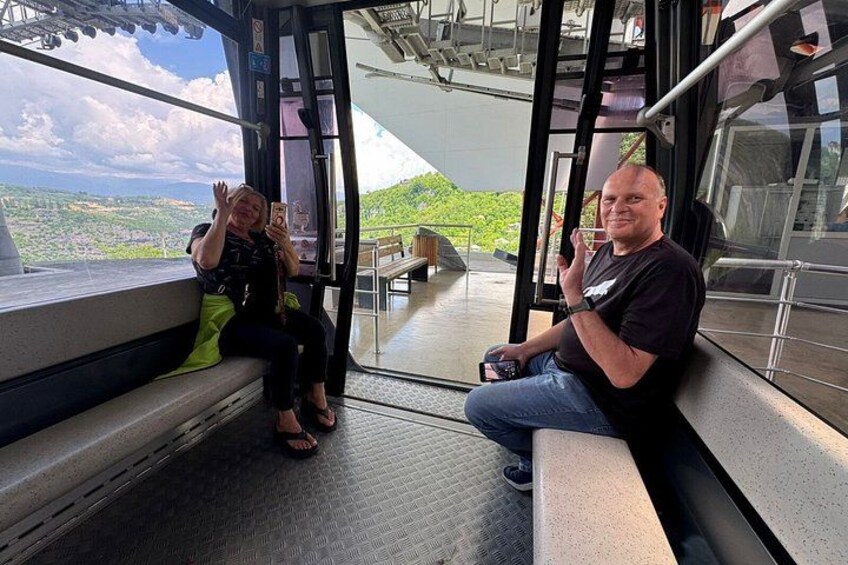 Two people sitting on a bench inside a vehicle with a view of a landscape. 3