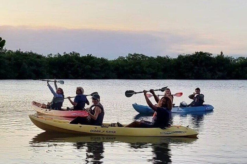 Two kayaks on calm water with people paddling. 3