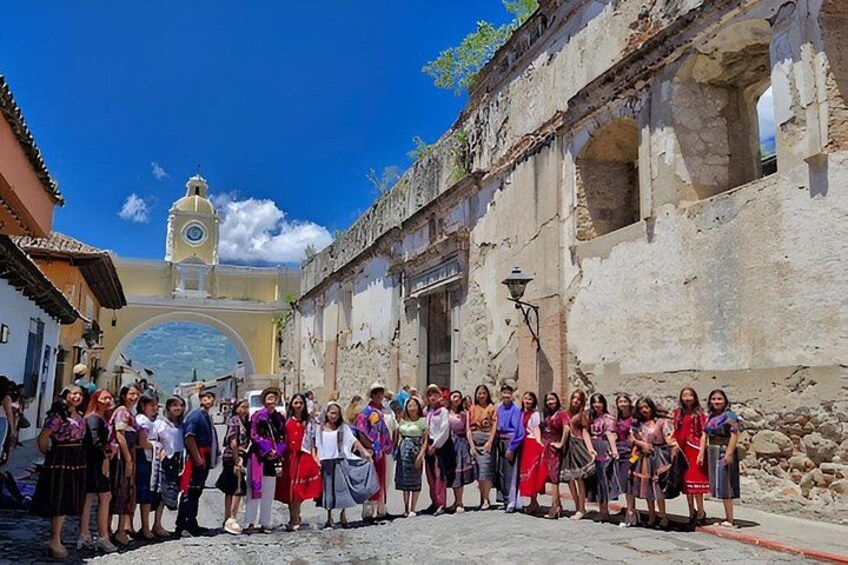 A group of people standing in front of a historical building with a clock tower. 5