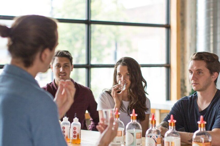 A group of people sitting around a table with bottles of beverages. 2