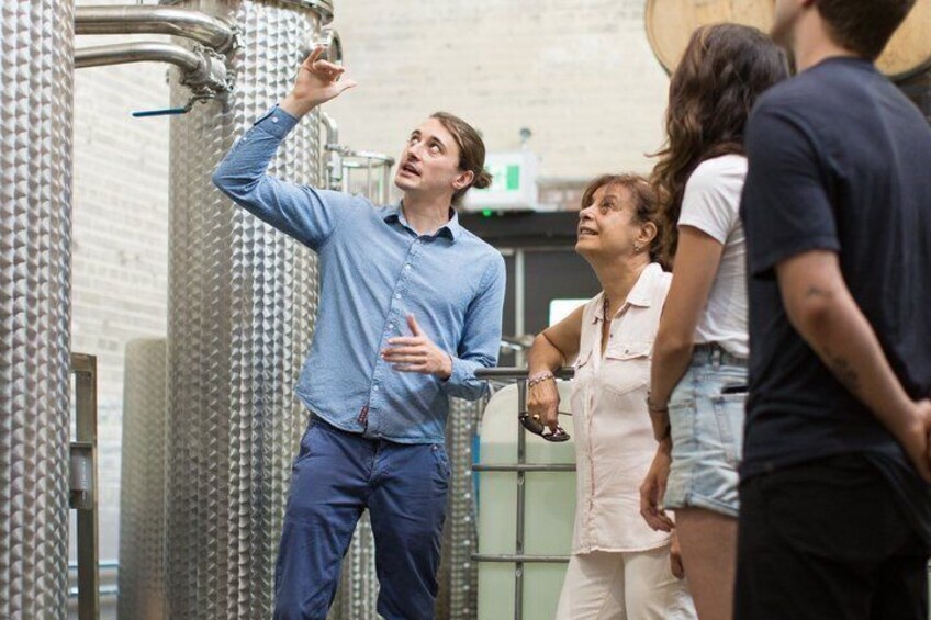 A person pointing at industrial equipment, possibly explaining it to others. 3