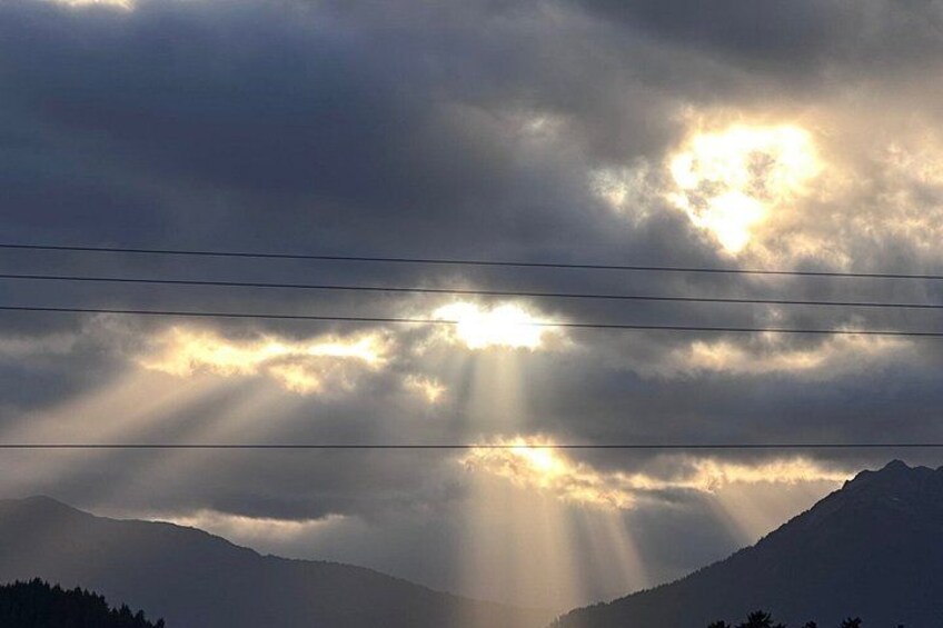 A mountain range with sunlight filtering through clouds. 2