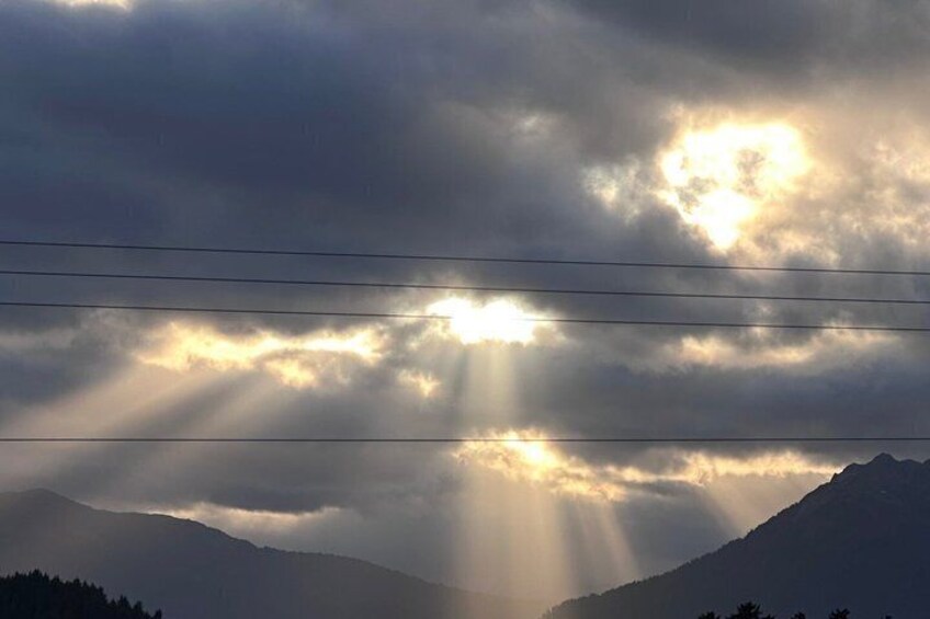A mountain range with sunlight filtering through clouds. 2