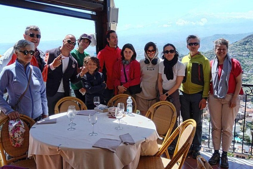A group of people at a table with a scenic view. 3