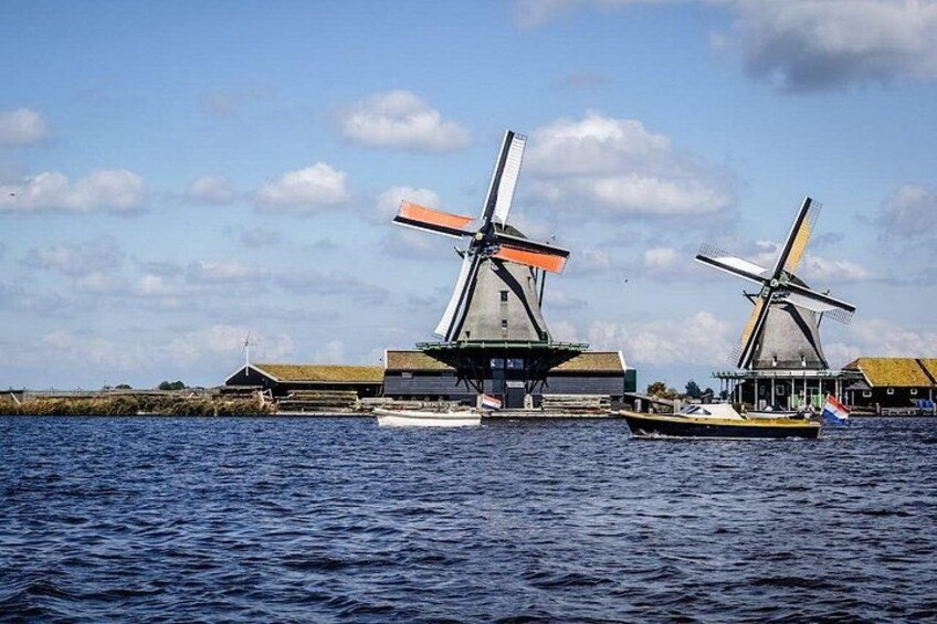 Windmills, a body of water, and buildings in the background. 5
