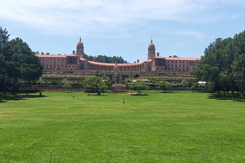 A large green lawn with a historic building in the background. 1