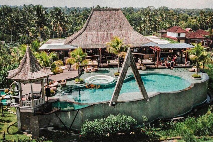 A resort with a large pool, lounge areas, and traditional-style buildings. 2