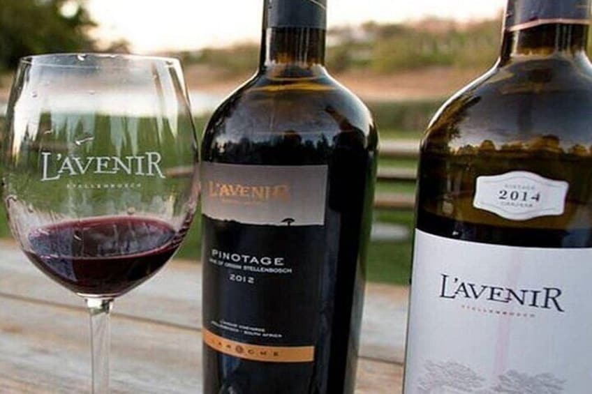 A wine glass, two bottles of L'AVENIR wine, and a label indicating 2014 vintage. 2