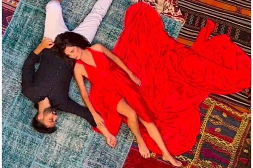 A person lying on a patterned carpet. 4