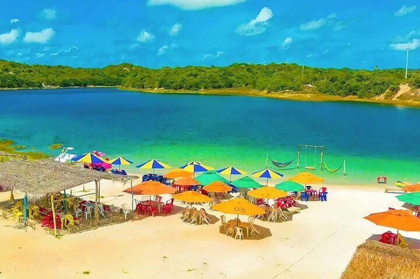 A beach with colorful umbrellas and a thatched-roof hut. 4