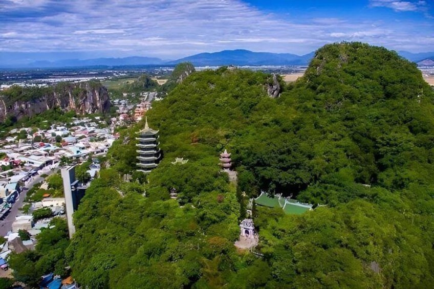 A mountainous landscape with a pagoda, lush greenery, and a distant view of a town. 3