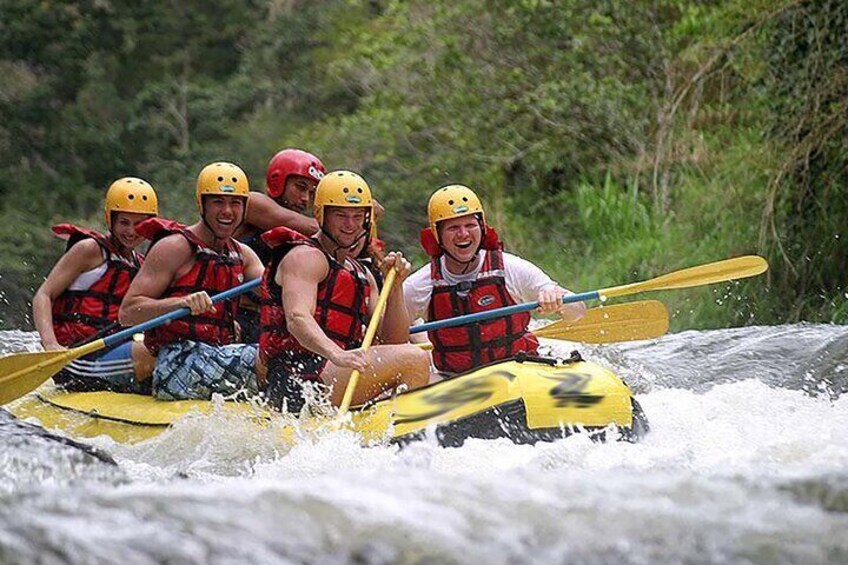 A group of people in a yellow raft navigating a river. 1