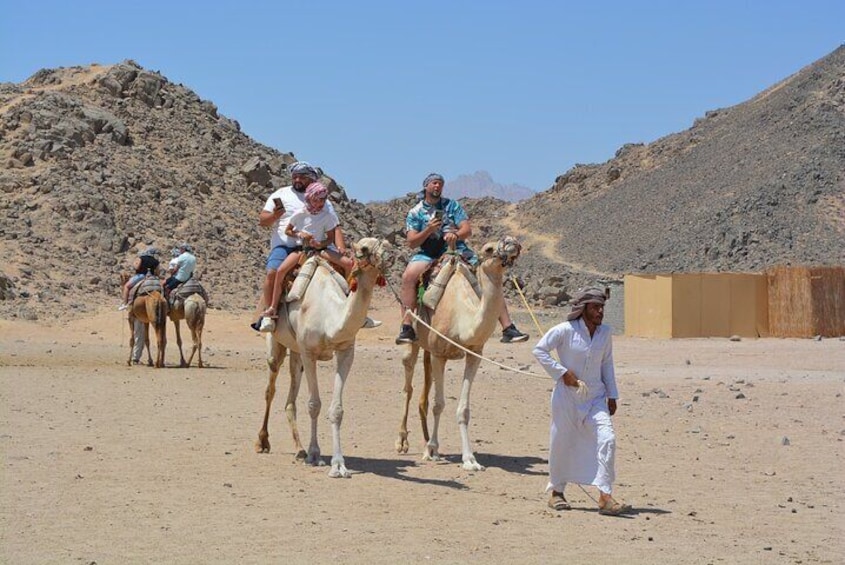 A desert landscape with camels and riders. 5
