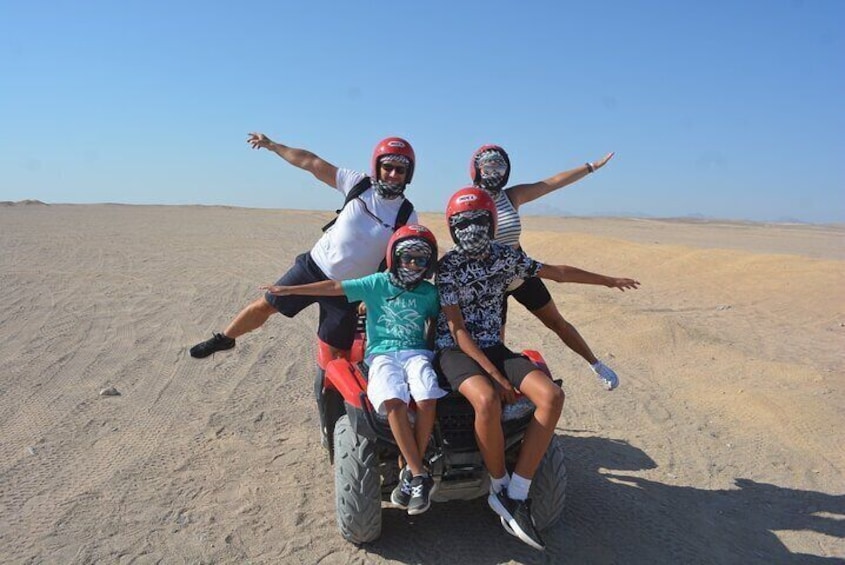 A group of people on a dune buggy in a desert. 2