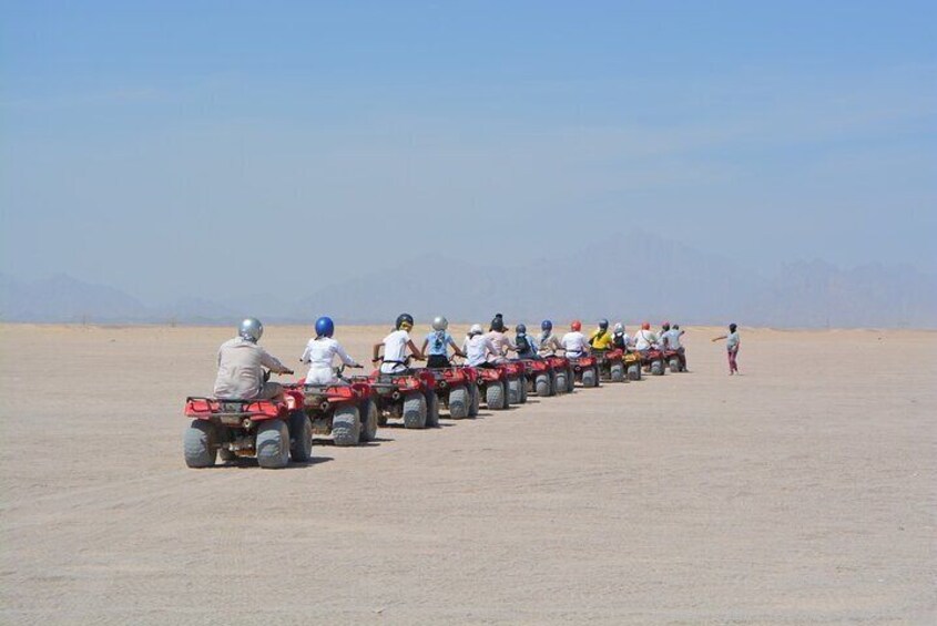 A group of people on ATVs in a desert landscape. 1