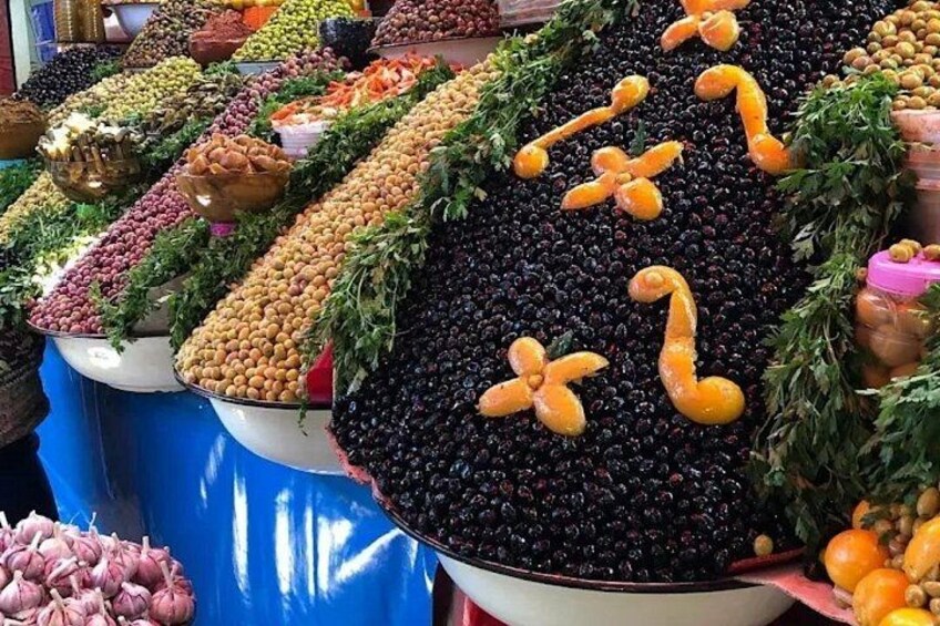 A market display with various fruits and vegetables arranged in large bowls. 2