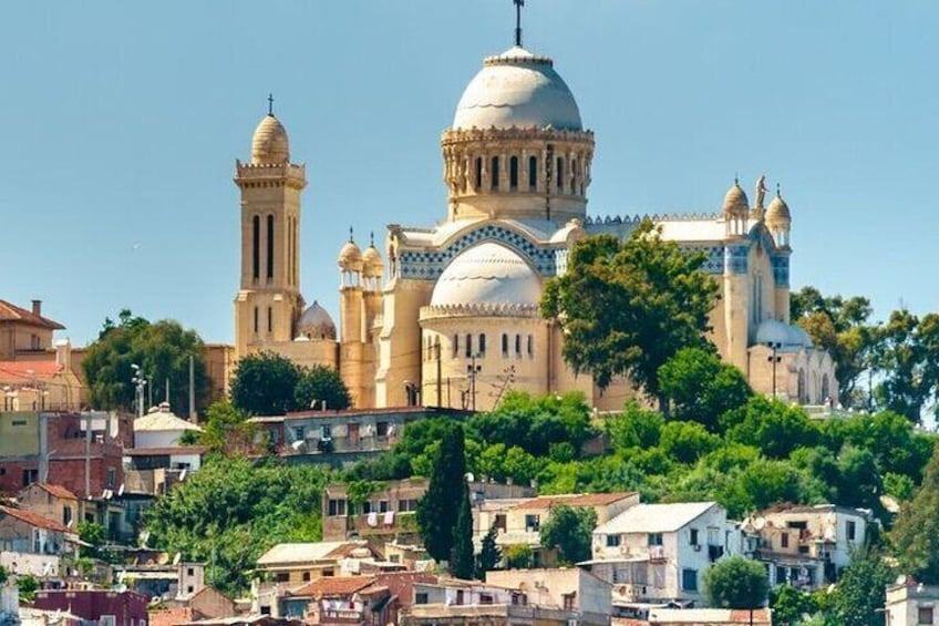 A large church with a prominent dome and bell tower, surrounded by residential buildings and greenery. 1