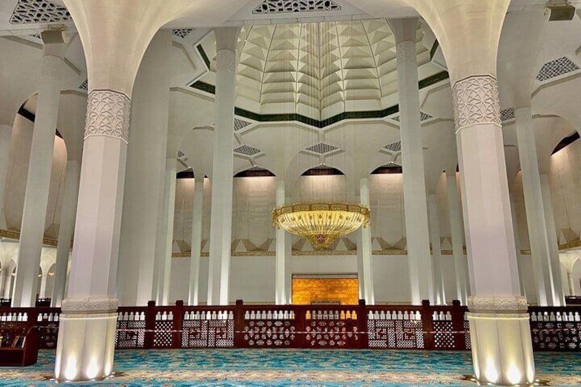 An interior with high ceilings, white columns, and a central chandelier. 4