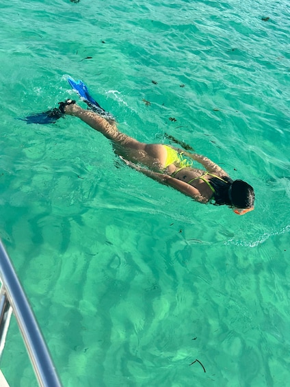 A person swimming in clear turquoise water. 5