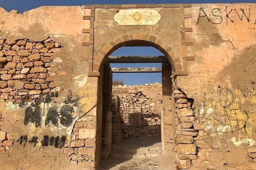 An arched entrance to a historical site with graffiti on the walls. 2
