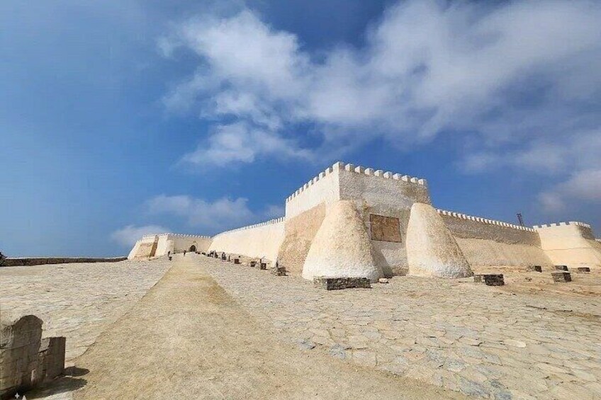 A fortress with a large central tower and a long wall extending into the distance. 4