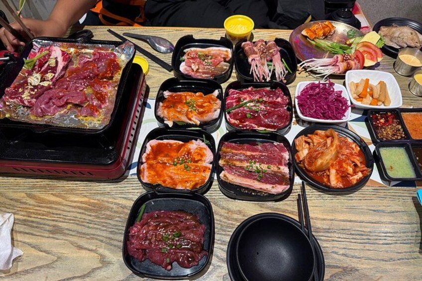 A variety of raw meats and sauces on a wooden table. 3