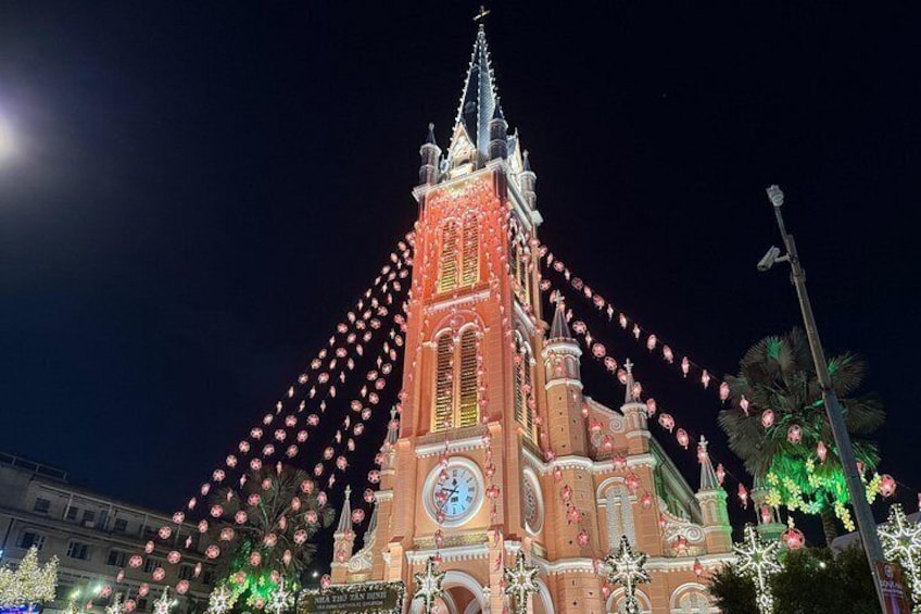 A lit-up church with a clock, surrounded by festive lights and decorations. 2