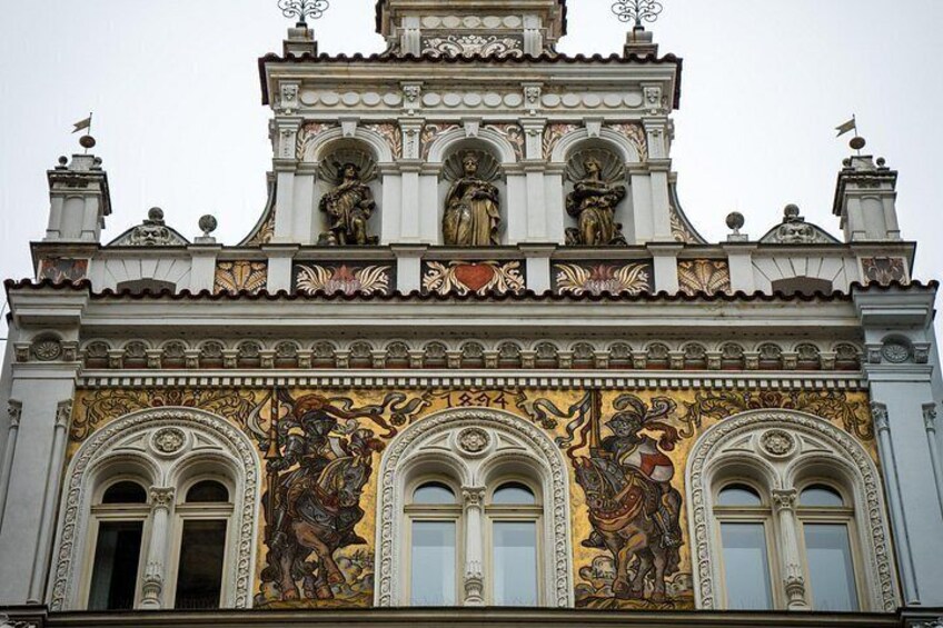 A building with ornate facades, detailed sculptures, and a large mural. 5