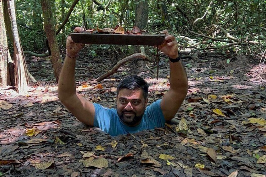 A person holding a wooden plank above their head in a forest. 4