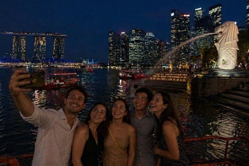 A group of people taking a selfie with a city skyline and a statue in the background. 1