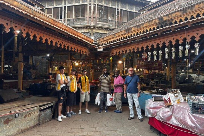 A group of people standing in a traditional building with ornate architecture. 2