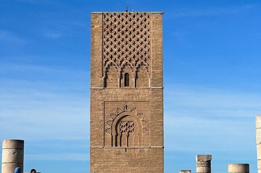 A tall brick tower with intricate carvings and a large arched window. 5