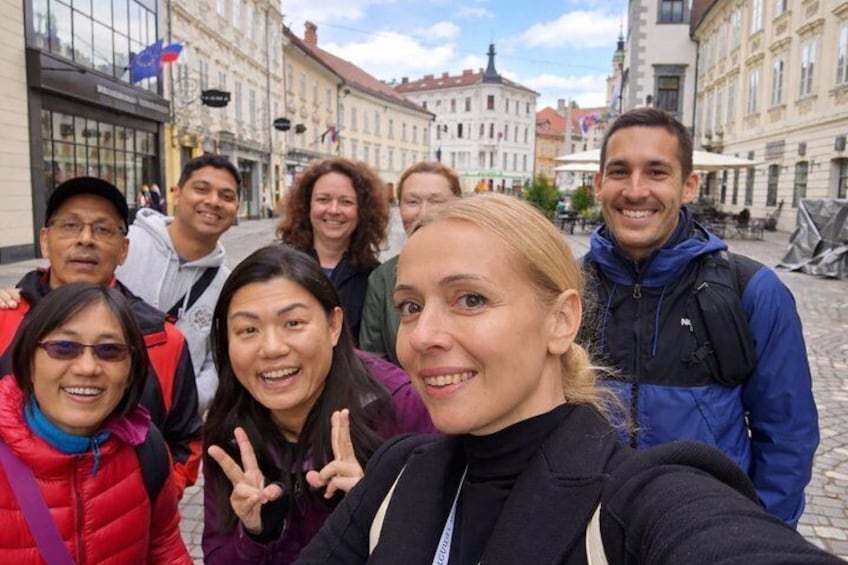 A group of people taking a selfie in a European city street with historic buildings. 1