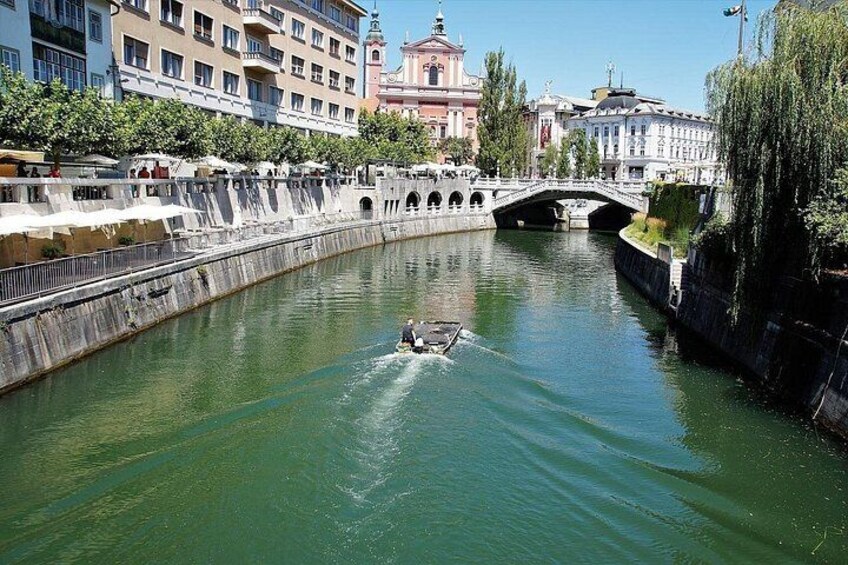 A river with a bridge, buildings, and a boat. 3