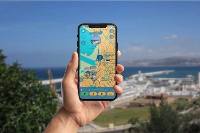 A hand holding a smartphone displaying a map with a coastal cityscape in the background. 2