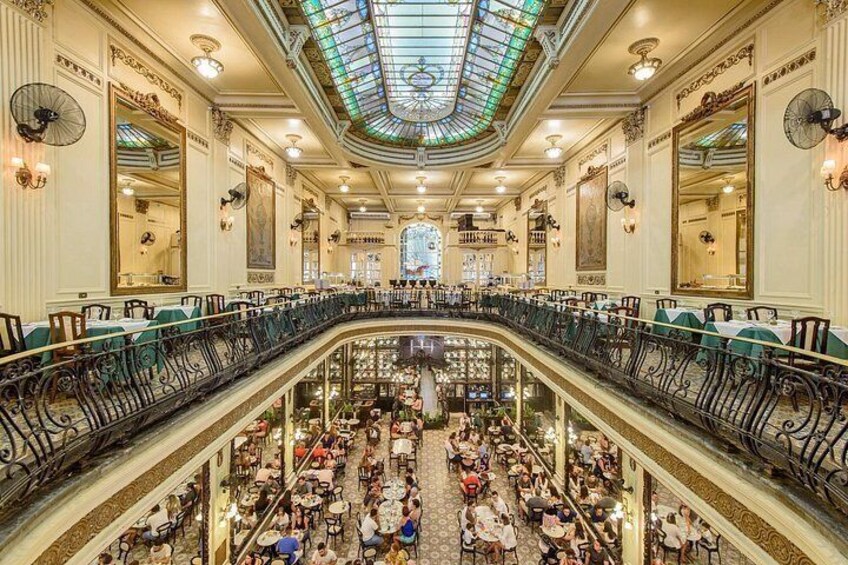 A grand, ornate interior with a central staircase, multiple levels, and a glass ceiling. 3
