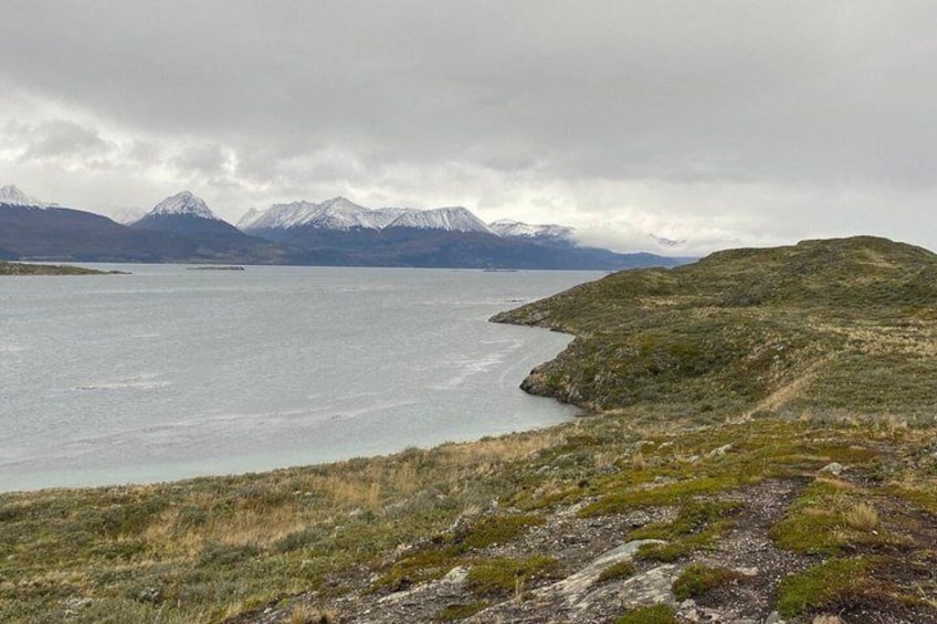 A lake with mountains in the background and a grassy shoreline. 2