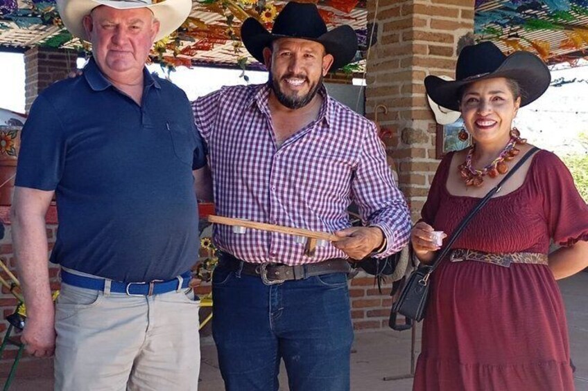 Three people wearing cowboy hats, one holding a wooden stick. 5