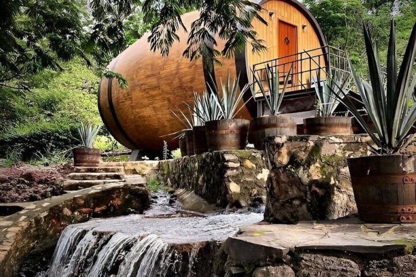 A wooden house with a cylindrical shape, a waterfall, and potted plants. 2