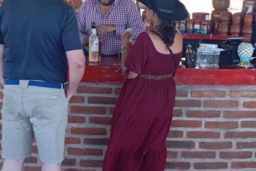 A brick wall with a red counter, a person in a blue shirt, and another in a red dress. 4