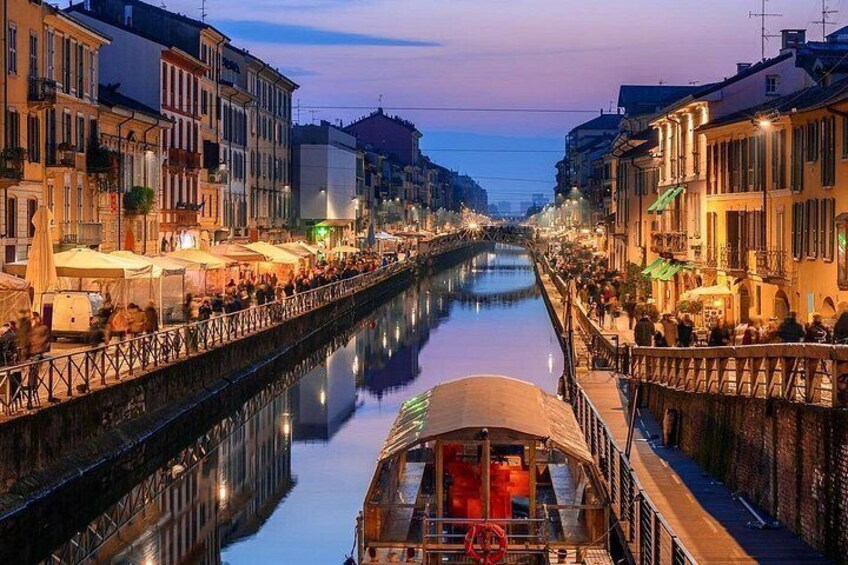 A canal with buildings on either side, a boat in the water, and a bridge in the foreground. 3