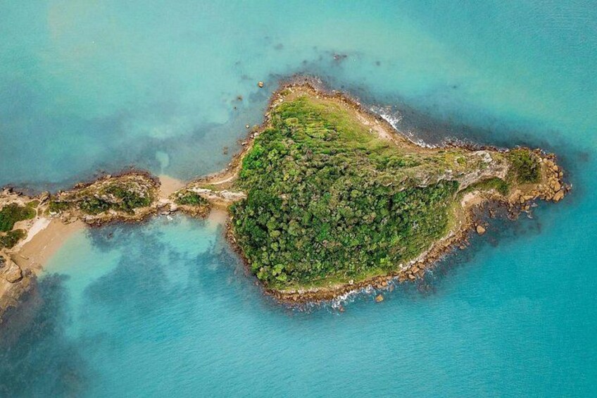 An aerial view of a lush, green island surrounded by turquoise waters. 2