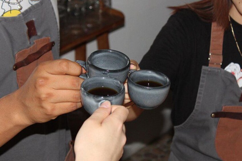A person holding four small ceramic cups. 3