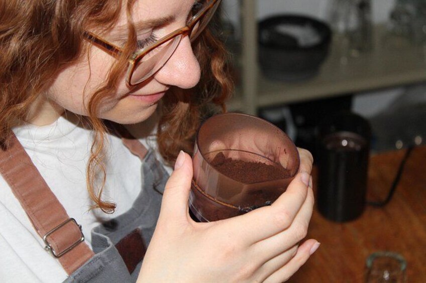 A person holding a glass with a brown liquid. 2