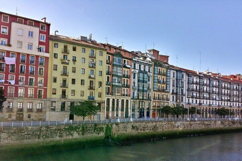 A row of colorful buildings along a riverbank. 2