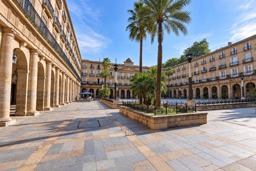 A courtyard with palm trees, a fountain, and classical architecture. 4