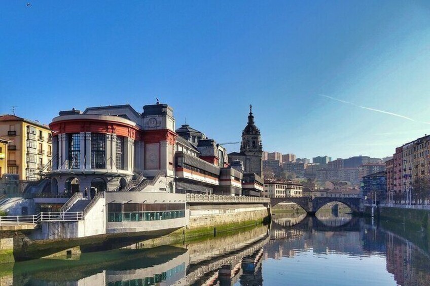 A river with a bridge, historic buildings, and a tower reflecting in the water. 5