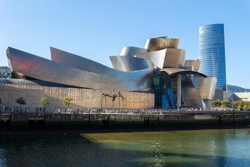 A modern architectural building with a unique, wavy facade and a tall skyscraper in the background. 4